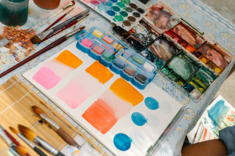 Watercolor palette, brushes, and practice sheet demonstrating flat, graded, and variegated watercolor washes for beginners.